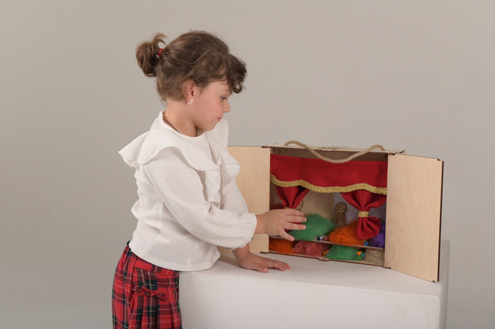 ბავშვი ხის თეატრით თამაშობს